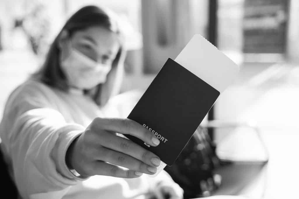 Consejos Para Inmigrar a los Estados Unidos 1 young woman in a mask sits in an airport lounge du 2022 01 05 07 44 00 utc